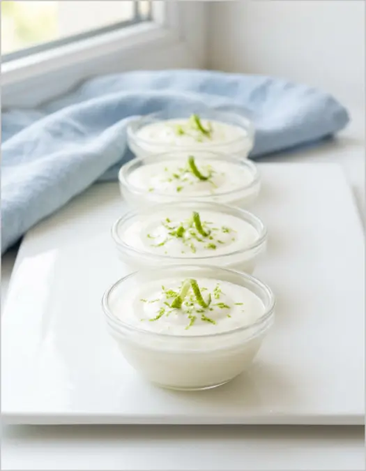 Quatre bols de mousse express au micro-ondes garnie de zeste de citron vert, présentation simple et appétissante