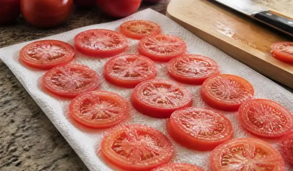 Tarte aux tomates mozzarella dorée au basilic frais sur une planche en bois